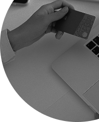 Hand holding a credit card near a laptop symbolizing e-commerce and digital transactions